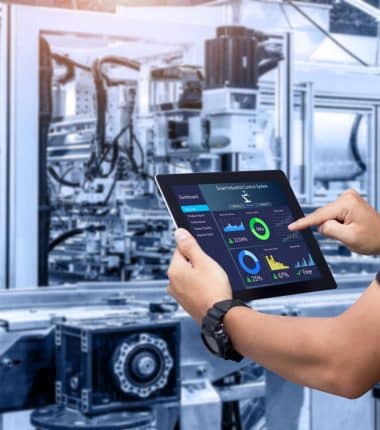 Opérateur contrôlant une machine industrielle via une tablette connectée